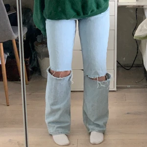 Jeans med hål  - Ljusa wide leg/straight leg jeans med hål på knäna jag är 1.55 och dem är rätt så stora i längden 