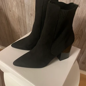 Svarta boots med klack - Dessa svarta boots från Nelly med klack köpte jag för ca 3 månader sen men säljer nu då jag inte haft användning av de och vill ha en annan modell skor. Jag har aldrig använt dom så de är fortfarnde så gott som nya :) De sitter dock bekvämt och tycker att de kan passa alla årstider.