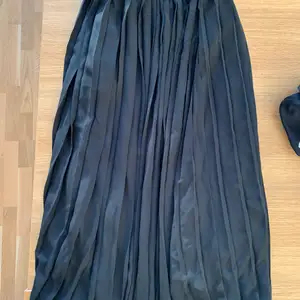 Plisserad kjol i polyester från UNIQLO. Storlek XS (24-25 inch). Använd 1 gång.