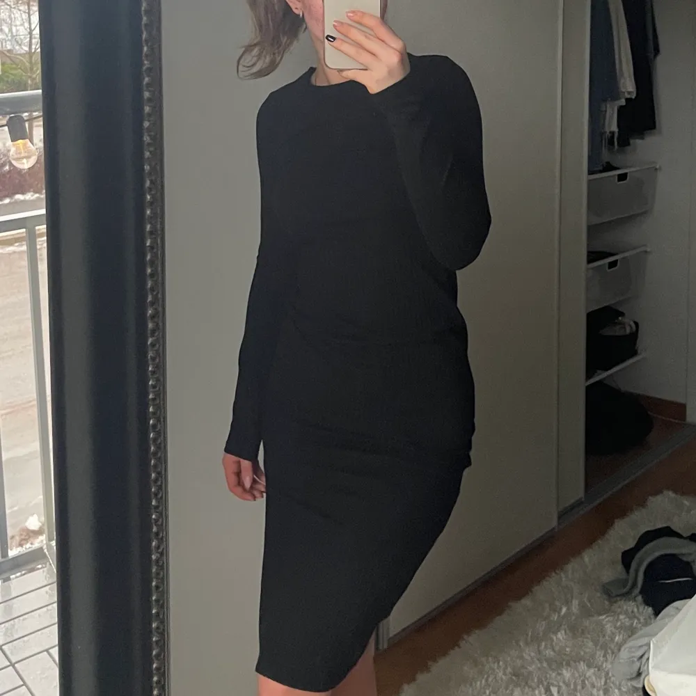En svart tajt klänning med en slits på vänster sidan, använd flitigt men är fortfarande i super fint skick🤍. Klänningar.