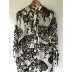 H&M Conscious katt skjortklänning - Snygg H&M Conscious « Wild cat » katt lång skjortklänning tunika. Storlek 34, lite stor i storlek. Nyskick. Knappar hela vägen och öppensida. Jättefint silky material. Längd: 112cm . Material: recycled polyester