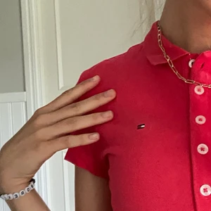 Tommy Hilfiger piké, rosa - Säljer denna SUPERHÄRLIGA pikétröjan från TH! Färgen är tvärfin när man har fått lite färg, har även funderat på att klippa till croptop för extra identit😍 säljer då den inte kommer till användning, köpare står för frakt ❤️