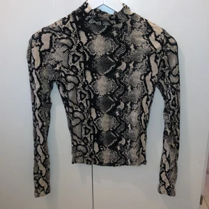 Polotopp i ormmönster - Polotopp i storlek XS från ginatricot.