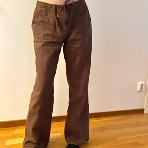 Bruna Linnebyxor - Fina, bruna linnebyxor (55% linne, 45% bomull) från Ellos, storlek 38 men justerbara tack vare knytbandet i midjan. De är i mycket bra skick förutom längst ner då jag råkade göra ett litet hål när jag sprättade upp fållen för att göra dem längre. Varken hålet eller att de inte är fållade stör, skulle inte säga att det är märkbart när man har dem på sig om de är tillräckligt långa, men skickar gärna bild på det. De är självklart nytvättade &jag kan både mötas upp i Lund & frakta mot fraktkostnad💗