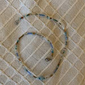 Halsband med blå/ bruna pärlor och en ljusblå sötvattenspärla 