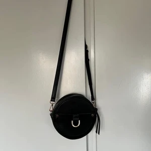 Rund svart väska - Liten rund väska i läderimitation med gulddetaljer och avtagbar rem som jag köpt begagnad. Ca 20cm diameter , känns som ny!  🖤116kr inkl spårbar frakt 