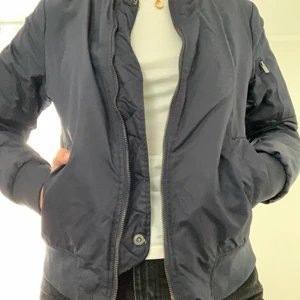 Bomberjacka Crocker  - En mörkblå jacka av märket Crocker i storlek small. Köpt för flera år sedan men använd under nåt halvår, så den är i fint skick! Den är fodrad och passar till våren! Har en ficka på vänster ärm och en innerficka. 