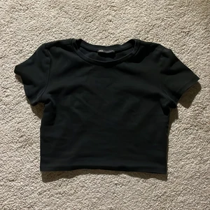 Topp - Svart croppad topp från zara i S, den är i fint skick (använd få gånger)  och den har inga fläckar eller hål.