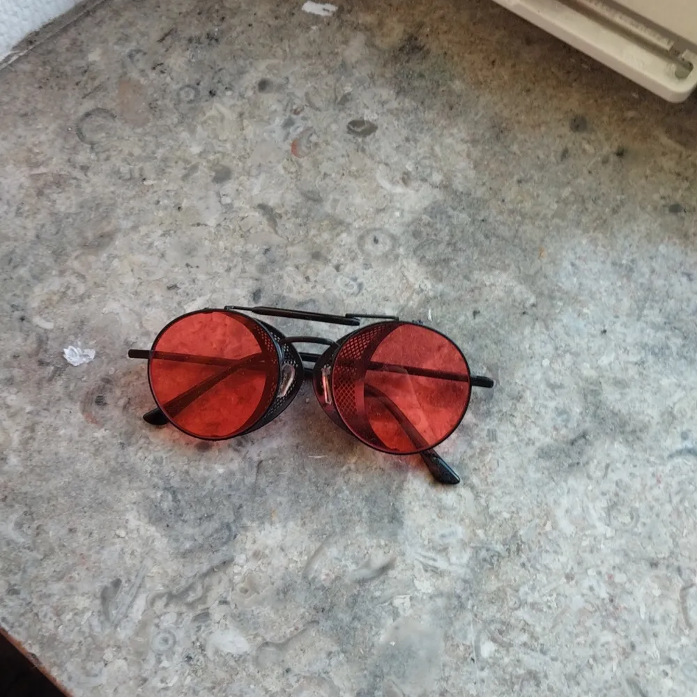 Röda glasögon med hopfällbara sidor(?), Svart båge. Accessoarer.