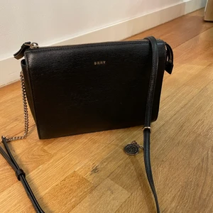 DKNY VÄSKA - En lite gammlare modell av DKNY väska. Köpt på NK. Använd ett fler par månader men ser helt ny och fräsch ut. Säljer pga att jag ej använder den mer. Köparen står för frakten!