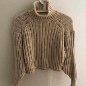 Beige stickad tröja - Fluffig och mjuk kabelstickad beige tröja från HM i storlek XS men passar XS-M. Tröjan är använd få gånger och kommer tyvärr inte till användning längre. Kragen går lika snyggt att ha uppe som nerkavlad. Perfekt längd på mig som är 164cm och har storlek M🤍