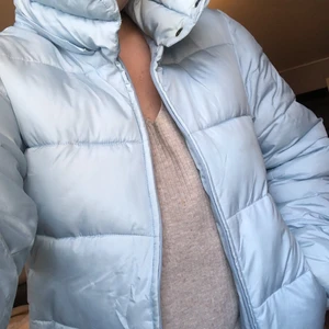 Ljusblå snygg ’dun’jacka - En härlig ljusblå/pastellfärgad jacka som passar perfekt nu till vinter/våren. Kort modell, strl S. Två stycken fickor med dragkedja fram samt en innerficka med dragkedja (luva saknas)  Fint och nästan oanvänt skick.  200kr + frakt