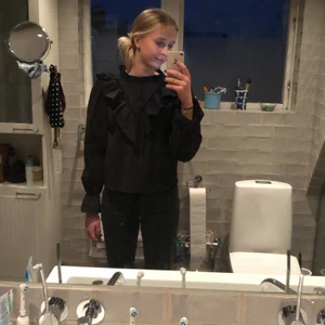 Gina tricot blus  - Superfin svart blus från Gina tricot. Den har volanger vid kragen och en knapp på baksidan. Använd 2 gånger och är i helt nytt skick💗💗