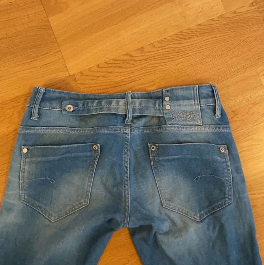 Blåa lågmidjade jeans med cool rumpa från G-Star. Passar mig som är ca 170. . Jeans & Byxor.
