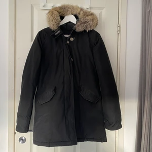 Lång vinterjacka - Lång vinterjacka från woolrich! Använd sparsamt men man ser att den har varit använd. Storlek S. Äkta päls. Mötas upp i Halmstad eller frakt 70kr. 