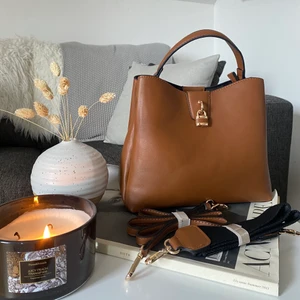 Brun handväska  - Säljer min fina bruna handväska🤎🤎  den är aldrig använd! Det tillkommer två band till väskan. Väldigt bra utrymmen i väskan, ett fack med dragkedja i mitten + ett mindre fack med dragkedja i de facket! Plus två sidor för utrymme! 