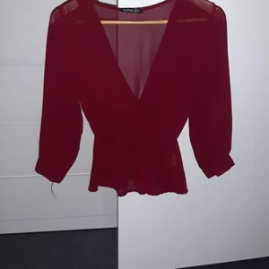 Blus - En vinröd blus användes en gång. Den är ej genomskinlig fast det ser ut som de. När man väll sätter på sig den så syns det ej igenom. 