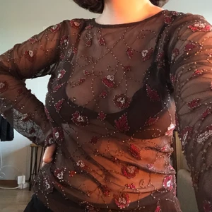 Brun blommig topp  - Brun topp med rosa röda blommor. I nyskick för har inte använt alls mkt, får ingen användning för den tyvärr. Frakt tillkommer på priset🌞