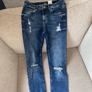 Blå jeans - Blåa håliga jeans. Storlek 28/30. 