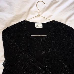 Svart, glittrande topp/kofta från TJ Collection! - En superfin, svart, glittrande topp/kofta med en halvlång arm inhandlat på en liten vintagebutik i LA från märket TJ Collection. Köpt för: 500kr Säljer för: 175kr 