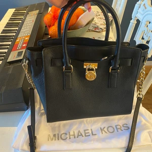 Svart Micheal kors - Hamilton med guld detaljer - Fin svart skinn väska med guld detaljer. Från Micheal kors 