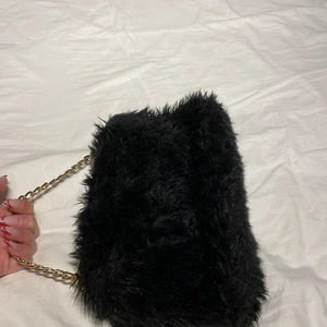 Fluffväska - med guldig kedja, använd fåtal gånger, jättefint skick, mjuk:)) två fack, går bra att ”vika in” kedja och ha under armen, så brukade jag ha den🖤 pm vid frågor/ önskemål om fler bilder 