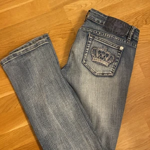 Lågmidjade jeans - Säljer snygga, lågmidjade, utsvängda jeans med tryck på bakfickorna från victora beckham.  💕 Använda men superfint skick. 