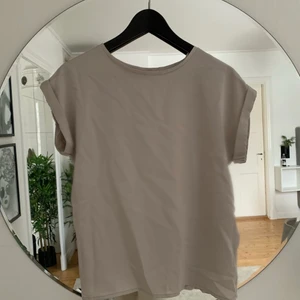 T-shirts  - Beige t-shirt i glansigt material där fram och ett mjuk t-shirt material där bak, använd 1-2 gånger