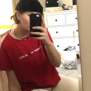 Oversized Tommy Hilfiger T-Shirt  - Oversized boxy T-Shirt från Tommy Jeans🕺🏻 Färgen är röd och representeras bäst på första och andra bilden. Storleken är XS men eftersom den är rejält oversized passar den även S/M beronde på hur man vill att den ska sitta. Jag är 170 cm lång och har oftast S/M och på mig sitter den oversized. T-shirten är boxy och är därför lite kortare vilket passar perfekt till högmidjade byxor eller en kjol. Vid intresse är det bara att höra av er så svarar jag så fort jag kan✨ Kram <3
