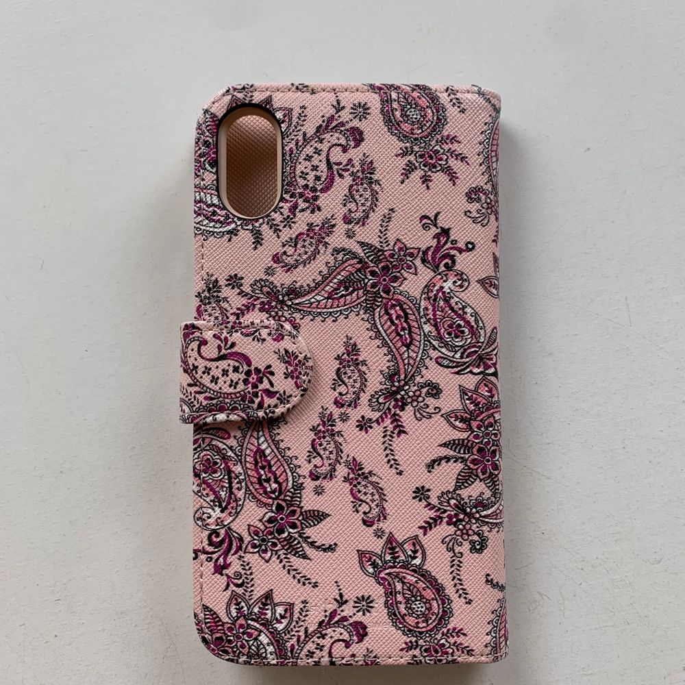 Rosa magnetiskt plånboksskal till mobilen med mönster på. Finns plats för tre kort + ett stort fack under. Kommer ifrån holdit och passar iPhone XR. Fint skick, nästan aldrig använt. Skalet kostar 100 kr, frakt ingår ej. Swipe för fler bilder.. Övrigt.