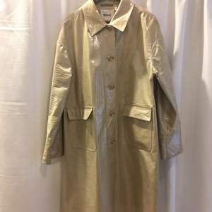 Kappa i linne och bomull, klädd i plast. Så en regntät  jacka! Går inte att tvätta, vissa fläckar, går säkert att torka bort. Upplever den stor i storleken. https://modesens.com/product/stand-studio-debbie-coated-canvas-raincoat-neutrals-18379639/