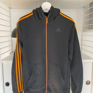 Säljer nu min Adidas hoodie som är mörkgrå med orangea detaljer! 
