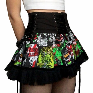 Episk kjol - Episk kjol från hellbunny!! Köpte den förra året men har endast använt den en gång:( Kjolen har dragkedja längst bak och snörning på sidorna och längst fram så man kan knyta den efter vad som passar. Snörningen get kjolen en korsettvibb. Mönstret efterliknar skräckfilmsmotiv från 80/90 talet. Kjolen är som sagt bara använd en gång så den har inga defekter eller fläckar!! Har du mer frågor eller vill ha mer bilder på kjolen skriv:D