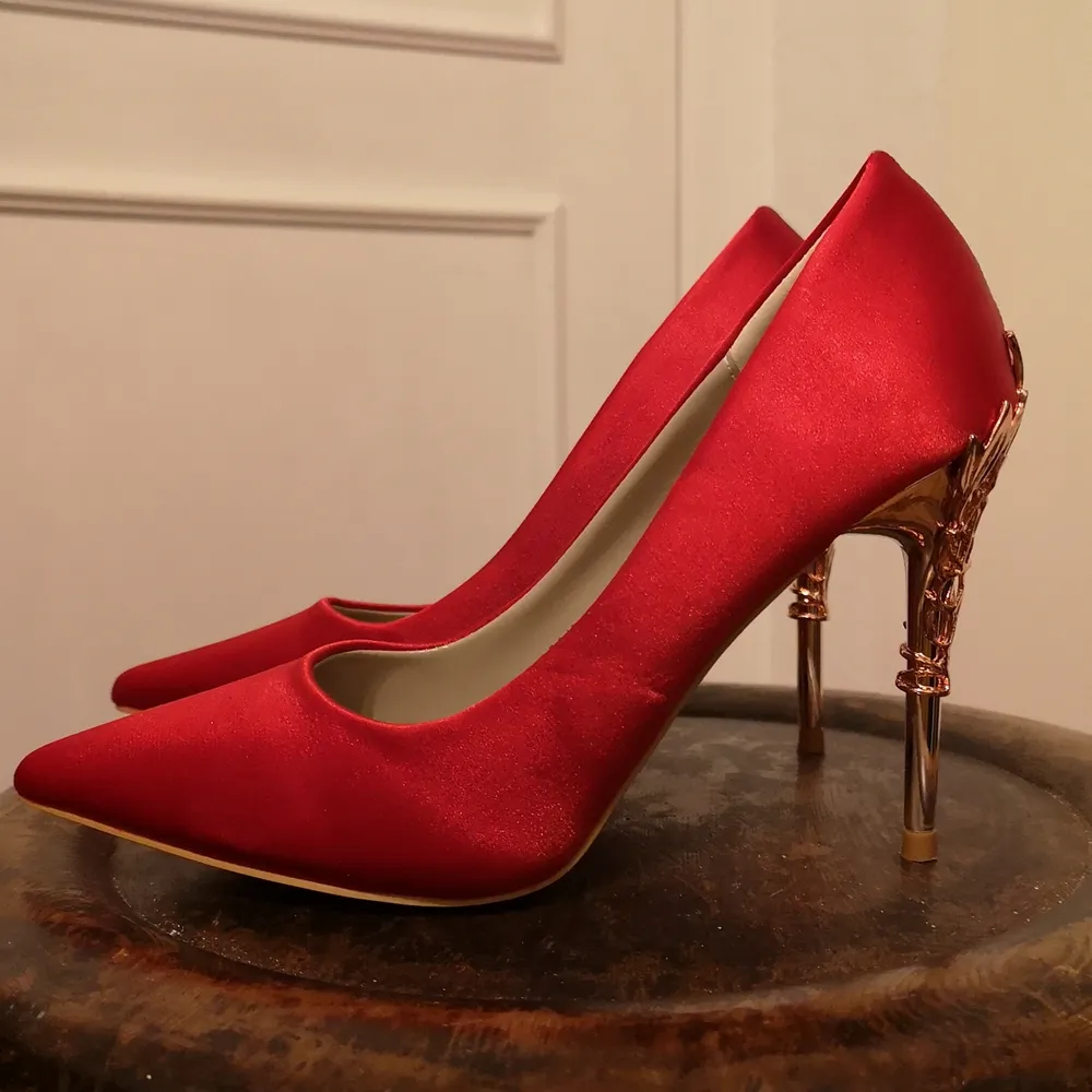 Oanvända röda skor med vackra stilettklackar. Silkigt rött tyg med fin glans. Spetsig tå. Storlek 36.. Skor.