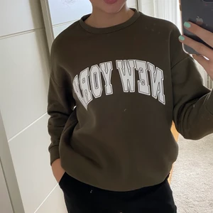 Sweatshirt  - grön/brun sweatshirt med texten new york på. storlek S💚🤎ingen fläck på tröjan utan på spegeln.