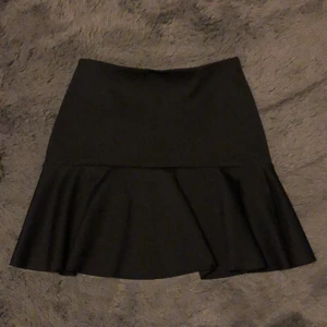 Lindex kjol strl M - Svart kjol men volanger och väldigt skönt material. Aldrig använd. Frakt ingår i priset!!