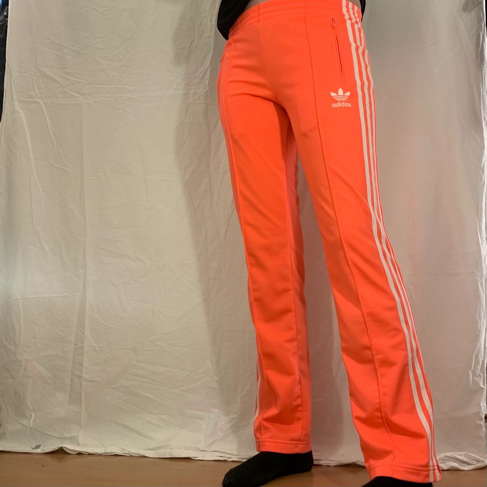 Orangea byxor med vita streck från Adidas. Fint skick. . Jeans & Byxor.