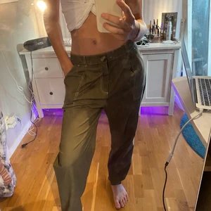 Gröna oversized byxor från gina - Assköna millitärgröna byxor från Gina, egentligen är dessa L i storleken men jag har använt dem som low waisted och om jag vill ha dem mer tajt har jag dragit åt dem med hjälp av knappen! Säljer pga att jag aldrig använder tyvärr