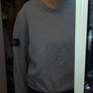 Grå stone island tröja - Äkta snygg och skön stone island, den är i bra tillstånd förutom att den har små hål i armbågarna och sliten vid händerna, pris 350kr plus frakt 🚚🌷