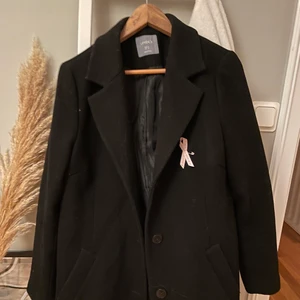 Svart kappa - Helt vanlig svart kappa från Lindex, använts förra vintern, men har inga defekter och ser inte använd ut. Svartare i verkligheten än på bilden. Säljer pga att jag vill ha mina kappor oversized. Passar dig som är mindre och vill ha en lösare passform eller en M som vill ha den perfekt. Frakt ingår inte i priset och kommer landa runt 70kr! Kan även mötas upp i Eskilstuna! 😊😊 