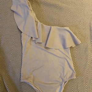 Vit baddräkt med en arm - Säljer denna baddräkten från H&M med en volang axel. Storlek 38🤍