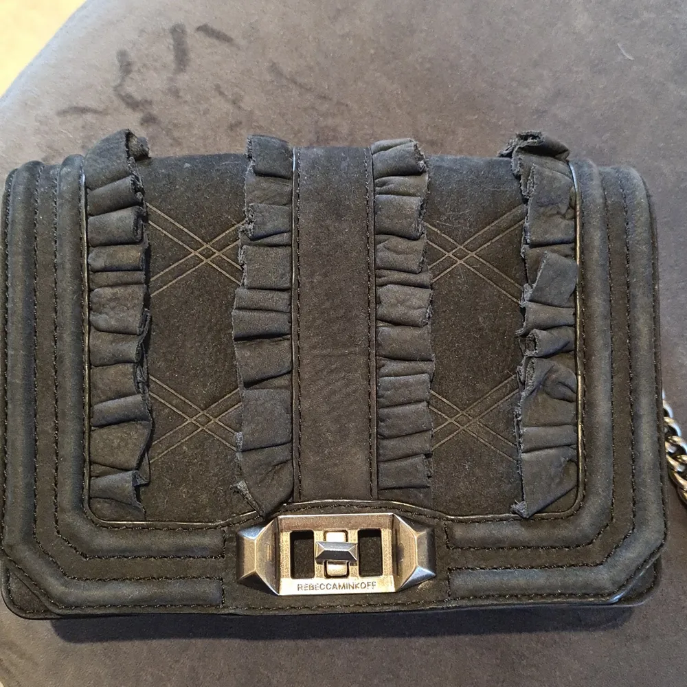 En axelremsväska från Rebecca Minkoff i äkta skinn och läder. En lång rem i läder och kedja som går att justera. Fint skick, knappt använd. Nypris ca 2000 kr. Ganska så liten, ca 20x15 cm. Förvaringspåse som väskan alltid förvarats i medföljer. Kan skickas spårbart för 66 kr.. Accessoarer.