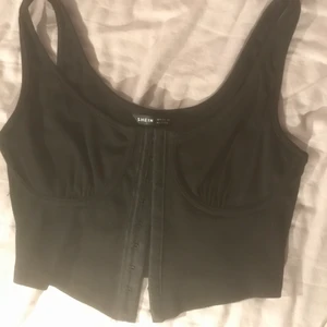 svart ribbad bralette - svart bralette med ribbat tyg och kupor (utan båge). knäpps ihop på framsidan. aldrig använd då den tyvärr är för liten. köparen står för frakt