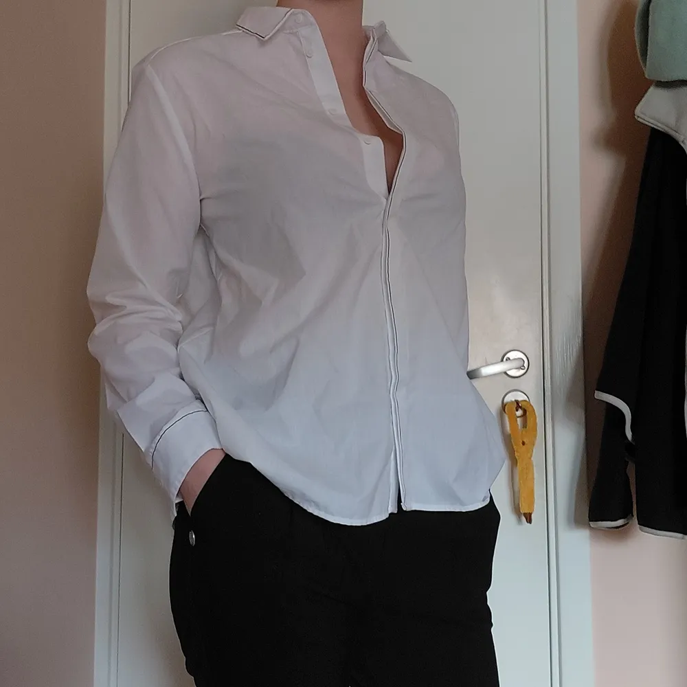 En festlig skjorta från Zara, med snygga svarta detaljer vid krage, knappar och ärm. Modellen är lite rakare och vidare nedtill. Säljer den då den är lite för liten för mig nu. Bara använd en gång! Köparen står för frakten men kan även mötas upp i gbg💛. Skjortor.