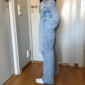Blåa byxor med hål från Zara - Säljer dessa blåa jeans med hål på knäna, från Zara. Jag är ungefär 160cm och det är storlek 36. Benen är avklippta. Kan mötas upp i Stockholm city eller skicka via posten!❤️