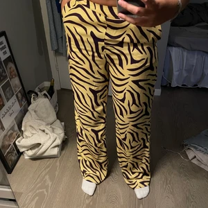 Vida kostymbyxor med mönster - Säljer dessa ascoola och unika brallorna från ivyrevel. Säljer då de tyvärr inte kommer till användning. De sitter tajt över låren och sen är de vida nertill vilket jag tycker är en väldigt snygg passform generellt. Byxorna är långa på mig som är 170 cm. Frakt tillkommer!