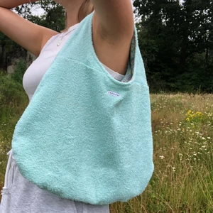 Handsydd mintgrön/mintblå frotté väska  - En så somrig mintgrön/mintblå strand- och sommarväska i modellen ”Karin” med blommig insida. Väskan går att vända ut och in, den blommiga sidan har två djupa fickor se bild 2.  Pris: 250 Frakt: 59kr 