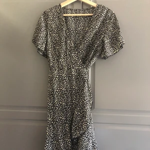 Sommarklänning  - En fin omlottklänning i svart och vitt, storlek M/L, endast provad. 