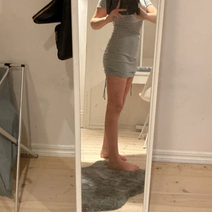 H&M klänning - Super snygg grå tajt klänning från H&M i storlek XS, säljer den för att den är för kort. 