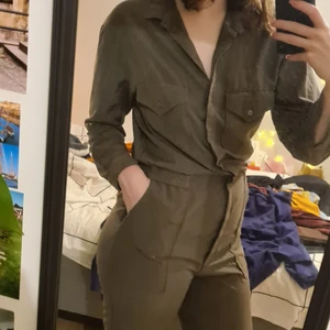 Skogsgrön byxdress/jumpsuit 38 - En av världens snyggaste jumpsuits! Älskar denna! ❤ Materialet känns riktigt, sitter rätt på rätt ställen, skön att sitta, gå och röra sig i. 🌟 Ser proffsig ut, resår i midjan, stängs med knappar. Man kan vika upp benen då det finns knapp (se bild 3). Perfekt för finmiddag, på jobbet eller en fin sommardag ❣☀️ Flitigt använd men den är precis lika fin som när den köptes! Garanterar!! Tidlöst och klassisk!  ❤
